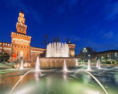 Sforzesco Castle and fountain in Milan, Italy at twilight.