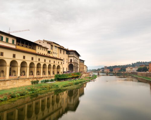 The Uffizi Gallery and the Arno River taken from the Ponte Vecchio bridge on the Arno River in Florence Italy.