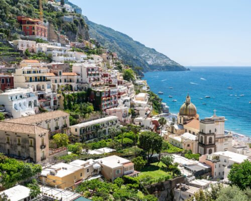 Street scape of Positano, located on the Tyrrhenian sea coast, Italy. Rows of residential buildings, church, greenery, beach