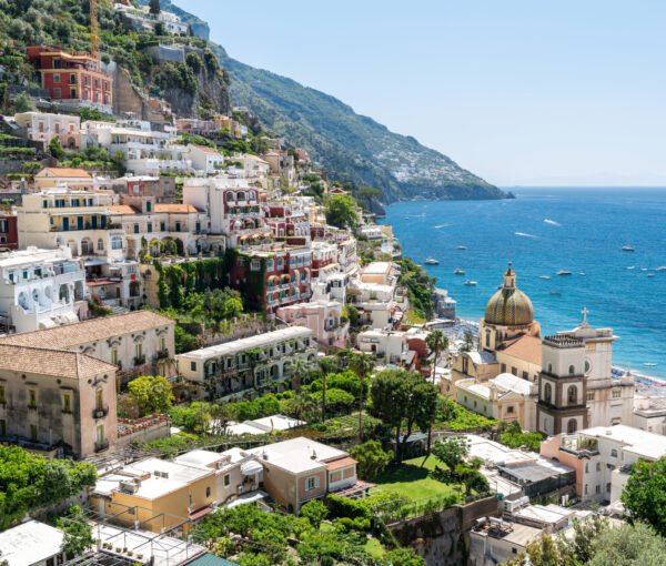 Street scape of Positano, located on the Tyrrhenian sea coast, Italy. Rows of residential buildings, church, greenery, beach